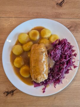 Śląski obiad rolada z kapustą na talerzu. Kluski śląskie.