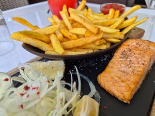 Obiad, smaczny tuńczyk z frytkami na talerzu. 