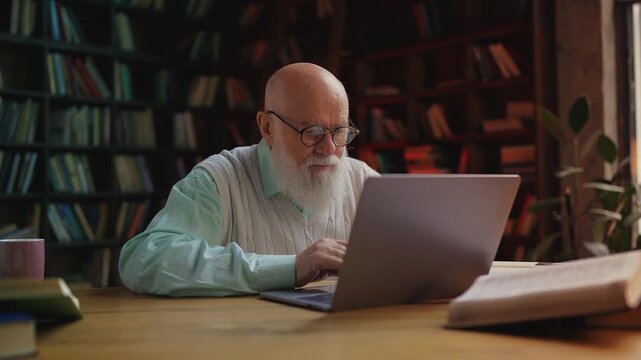 Elderly male scientist finishing work and closing laptop, tired from research