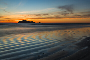 ニュージーランド　ホークスベイのヘイスティングスにあるワイマラマビーチからの早朝のベア島と朝焼け空