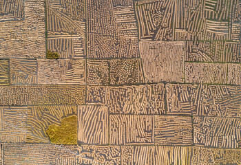 Aerial view of golden paddy fields create a patchwork of textures and patterns, reflecting the sunlight in Thakurgaon, Thakurgaon District, Bangladesh.