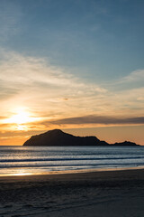 ニュージーランド　ホークスベイのヘイスティングスにあるワイマラマビーチからの早朝のベア島と昇る太陽