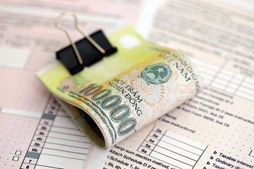 Vietnamese dong money bills on tax form. Taxation and accounting concept