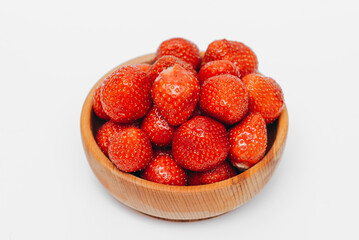 red strawberry berries in wooden cup, isolated on white backgroung, tasty and delicious
