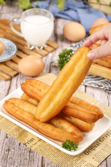 Crispy fried fritters being served with fresh ingredients for traditional snack preparation
