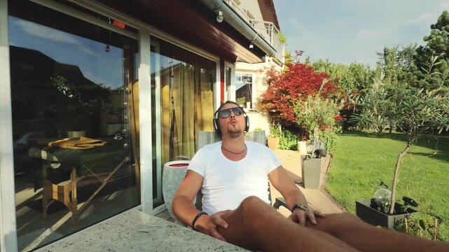 Man relaxing on patio in white t-shirt
