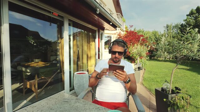 Wide shot of man seated in lush garden