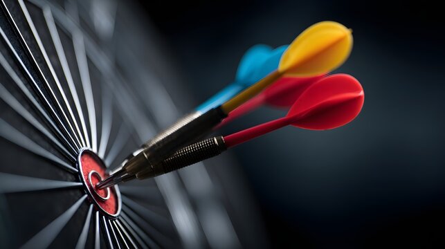 Three colorful darts aimed at the bullseye of a dartboard.