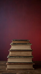 Stack of Old Vintage Books on Wooden Table with Burgundy Background Representing Knowledge History and Education