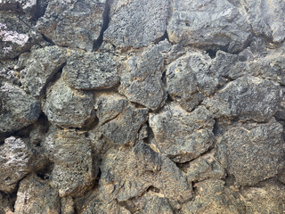 Hard black lava stone rock wall background