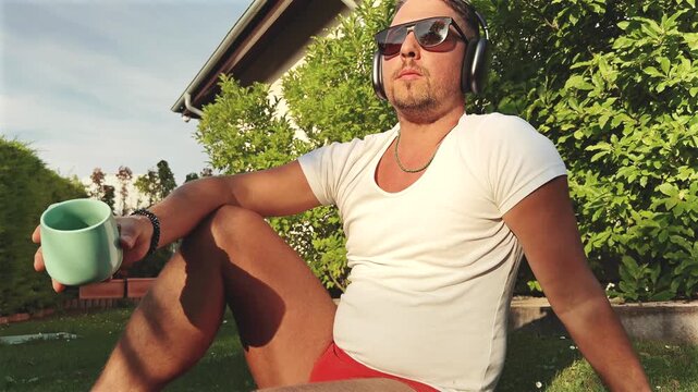 Man Sitting with Mug on Lawn During Sunset