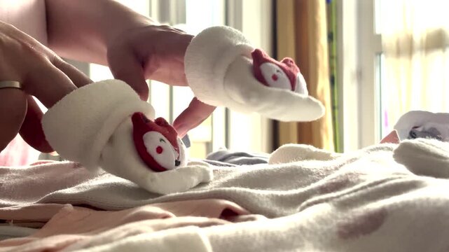 Pregnant young woman walking baby socks across her belly, Dolly shot
