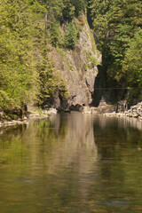 Fototapeta premium Sheer Rock Face and Still Water Near Capilano River Facility, Canada