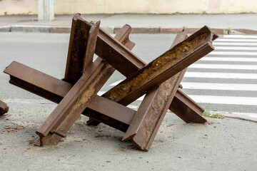 Rust-Covered Anti-Tank Barrier on City Street