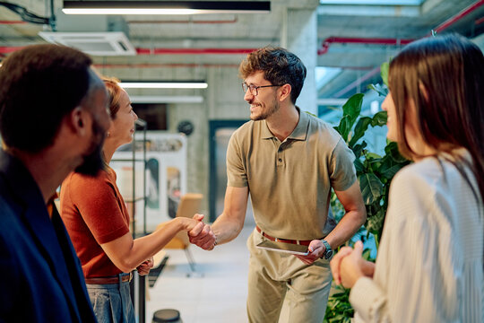 Business team welcoming a new employee with a handshake in a modern office, fostering collaboration and building strong connections