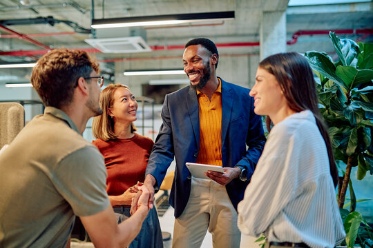 Business team collaborating and shaking hands during a productive meeting in a modern office, fostering partnership and teamwork