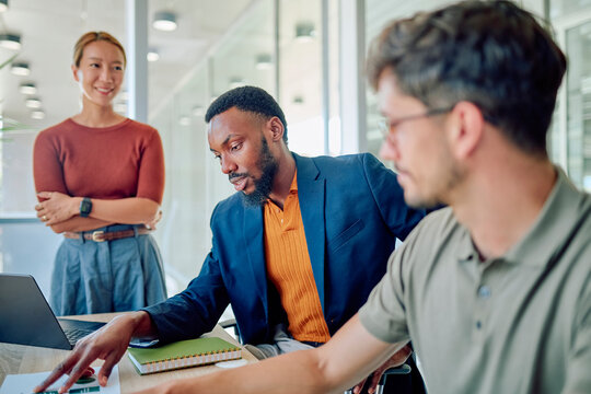 Business team collaborating on marketing strategies during a meeting in a bright, modern office, utilizing technology and data analysis