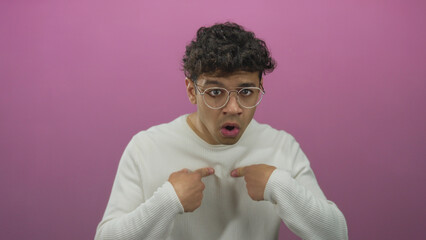 Man pointing finger to chest with open mouth and raised eyebrows in pink studio; surprise...
