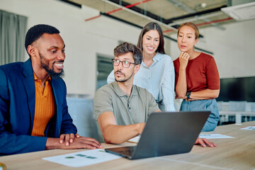 Business team collaborating on a project, analyzing data on a laptop and discussing strategies in a modern office environment
