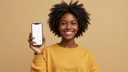 A smiling woman with curly hair holding a smartphone with a blank screen in her left hand