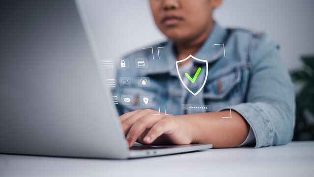 Cyber security concept showing Asian boy using laptop with digital interface, symbolizing online safety, data privacy, and child internet protection.