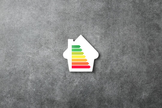 Energy efficiency scale on the house shaped on a stone background. Cost savings and low energy eco friendly home concept. Top view, flat lay.
