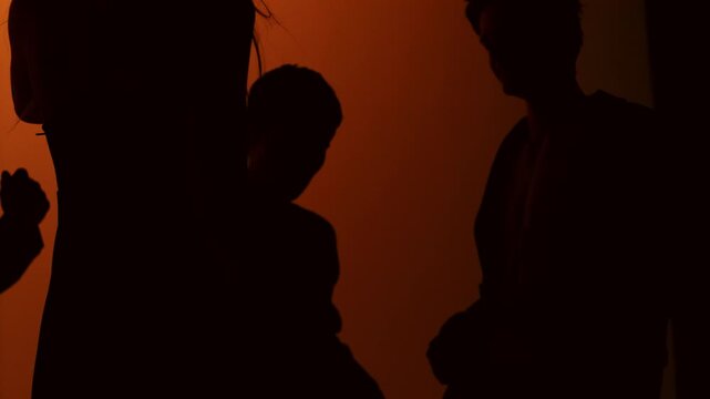 Extreme slow motion silhouette of young people dancing. Four friends move energetically against a bright background, captured at 1000 fps with a Phantom camera. Cinematic 4K ultra slow motion creating