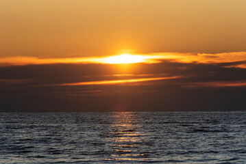Beautiful vibrant sunset sky over a calm ocean.
