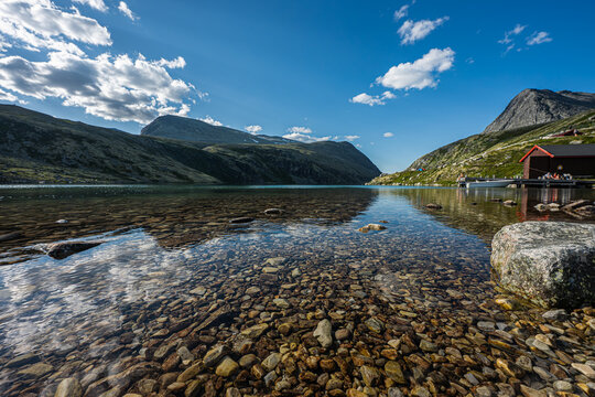 Norwegian summer, crystal clear lake in the highlands, lakeside landscape with boathouse and tent, Rondvatnet, Rondane, summer in Norway