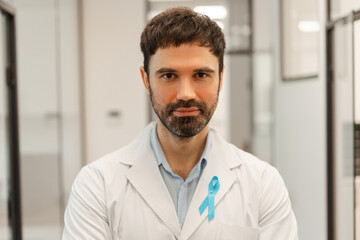 Doctor wearing light blue ribbon showing support for prostate cancer awareness month