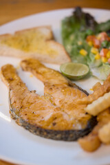 Salmon fish fillet grilled steak, close up of white dish.