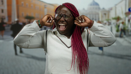 Woman shouting with hands over ears in an energetic expression at st. peter's square in vatican...