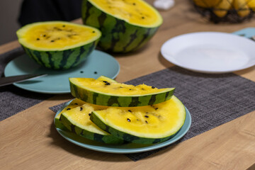 Close up shot of the cut watermelon with yellow flesh on ceramic plate. Food