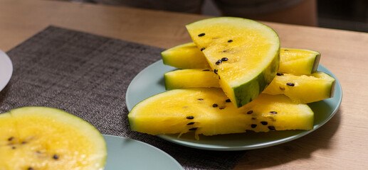 Close up shot of the cut watermelon with yellow flesh on ceramic plate. Food