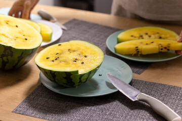 Close up shot of the cut watermelon with yellow flesh on ceramic plate. Food