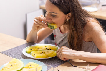 Woman eating watermelon with yellow flesh. Food