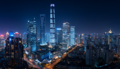 Fototapeta premium Modern city skyline illuminated at night with blue and white lights