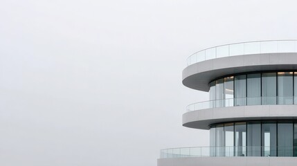 Minimalist modern architecture with curved balconies and glass facade against a clear sky, showcasing contemporary design and urban elegance.