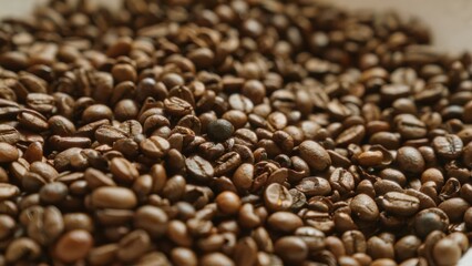 Closeup of roasted coffee beans showcasing rich brown textures and aromatic quality in a background suggesting freshly brewed beverages