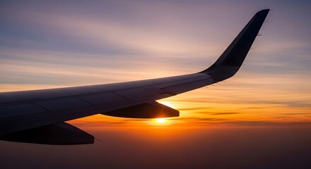 Obraz premium Aerial view from an airplane window showing the wing against a vibrant, colorful sunset sky, symbolizing a journey and new horizons.