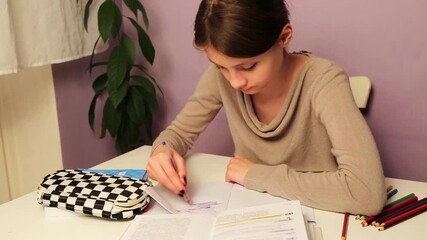 Fun cute tired emotion kid girl doing home exercises sitting at the table with book, copy books, pens, pencil case reading school book. Back to school. Concept education portrait video