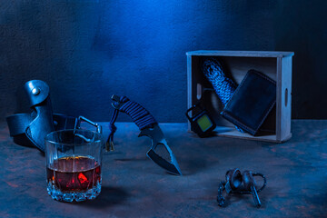 Hunting skinner knife and glass of whiskey on rustic surface.