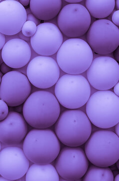 An interior or exterior wall decorated with lots of purple balloons as a backdrop