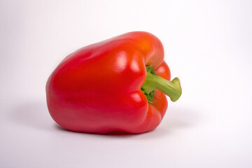 a red pepper with a green stem on a white surface