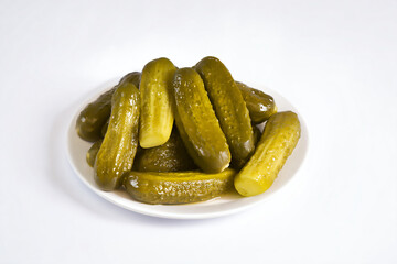a plate of pickles on a white surface