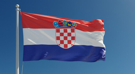 The Croatian national flag fluttering in the soft morning wind, isolated against a clear, cloudless sky.