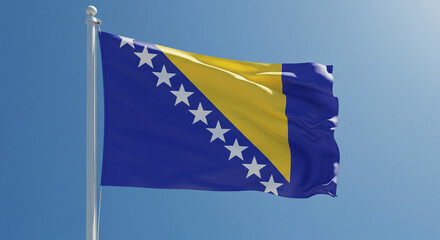 The flag of Bosnia and Herzegovina waving in the morning breeze, with a clean blue sky behind it.