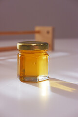 Close-up of golden honey in glass jar. Natural food with minimalist background.