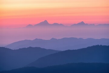 Serene mountain layers bathed in the soft hues of a vibrant sunrise