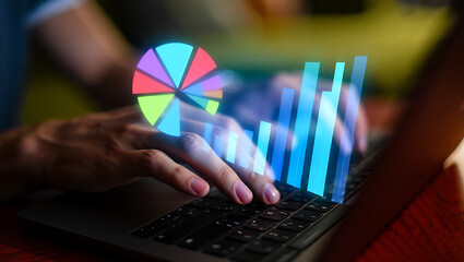 Hands typing on laptop with glowing charts and graphs image
